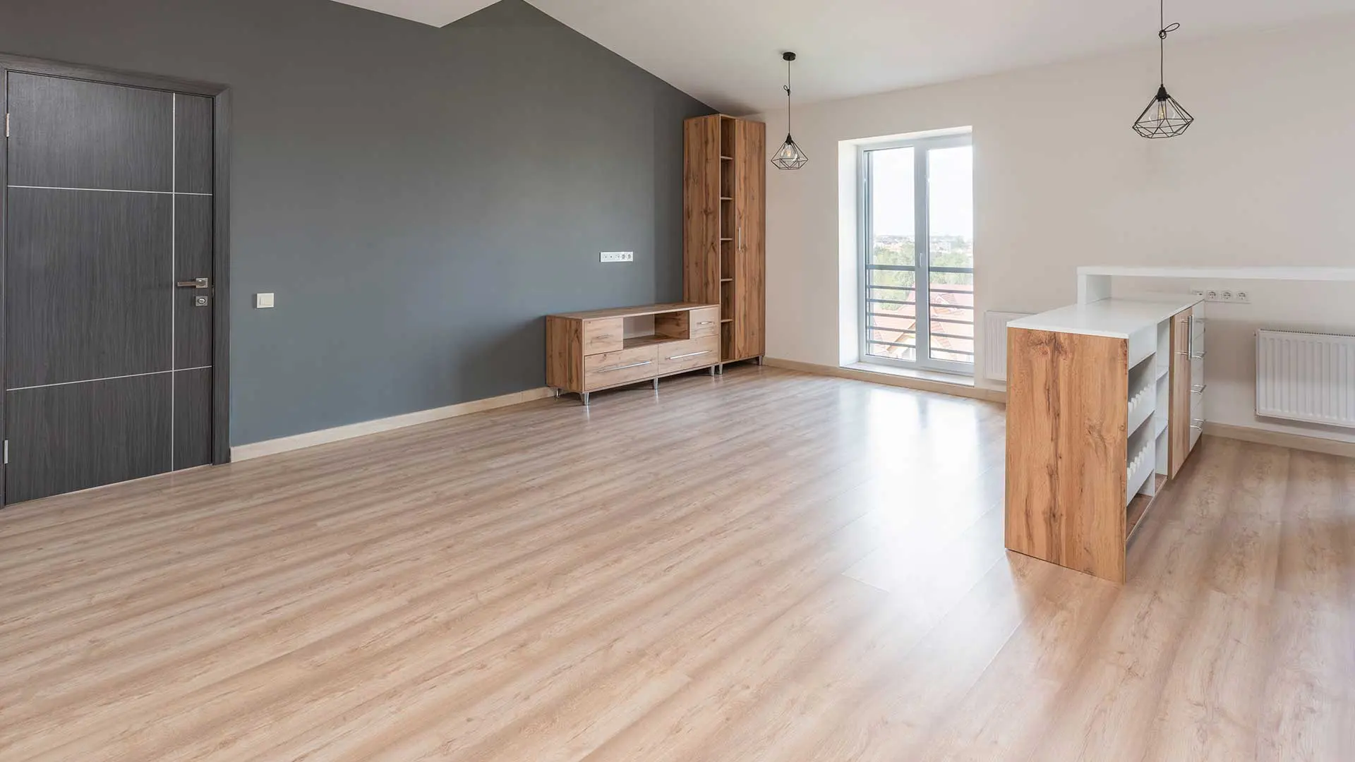 empty living space featuring a partial dark gray accent wall, minimalist wooden furniture pieces