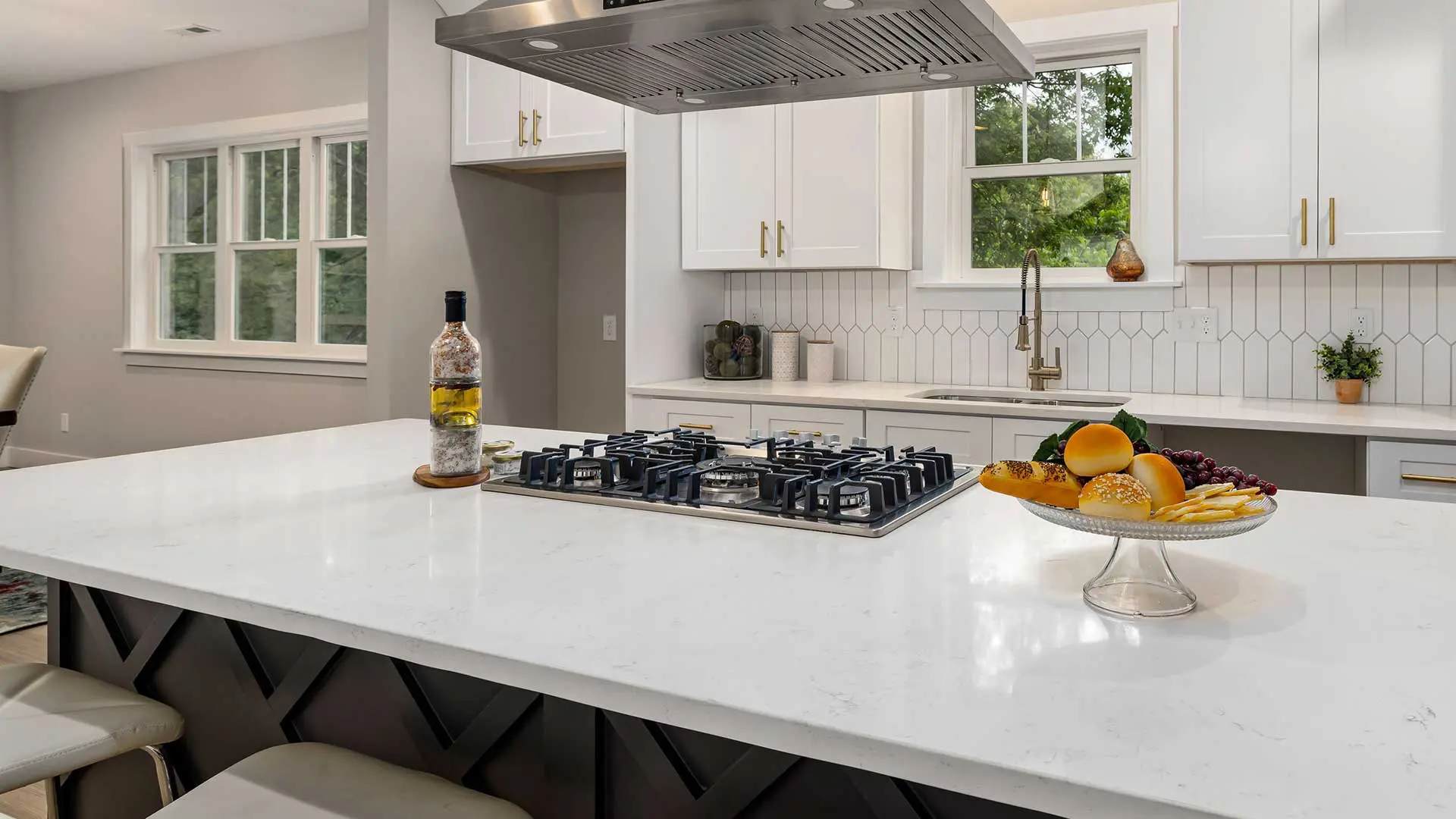 modern kitchen with a large white quartz island featuring a built-in gas cooktop