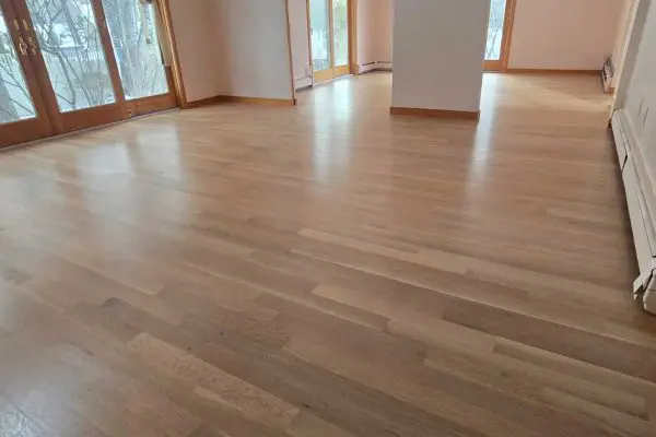 expertly refinished smooth satin light hardwood floors in a spacious room with wooden glass doors in revere ma