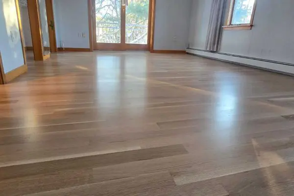 seamless connection between a modern kitchen and an expansive living room featuring newly completed light oak flooring in revere ma