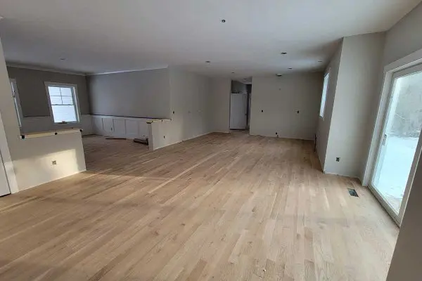subtle sunlight reflecting off a fresh satin clear coat on newly restored light wood floors in a revere ma house