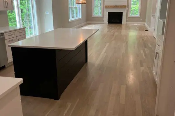 brightly lit entryway featuring custom white wainscoting a matching wood staircase and pristine light hardwood floors in revere ma