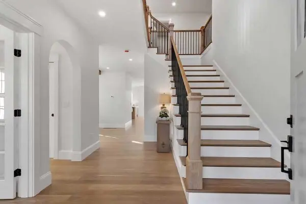 bright home foyer showcasing a matching hardwood staircase and light oak floors installed in the revere ma area
