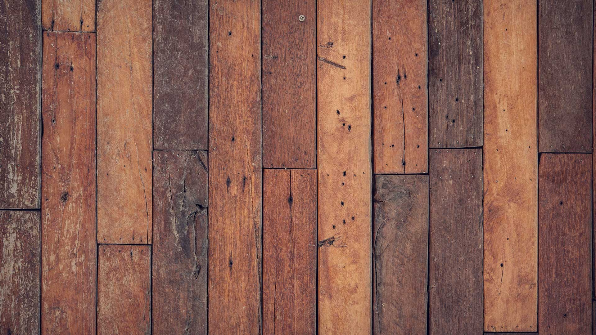 top-down close-up view showing a rustic, weathered arrangement of vertical wooden planks with distinct grains and visible knots