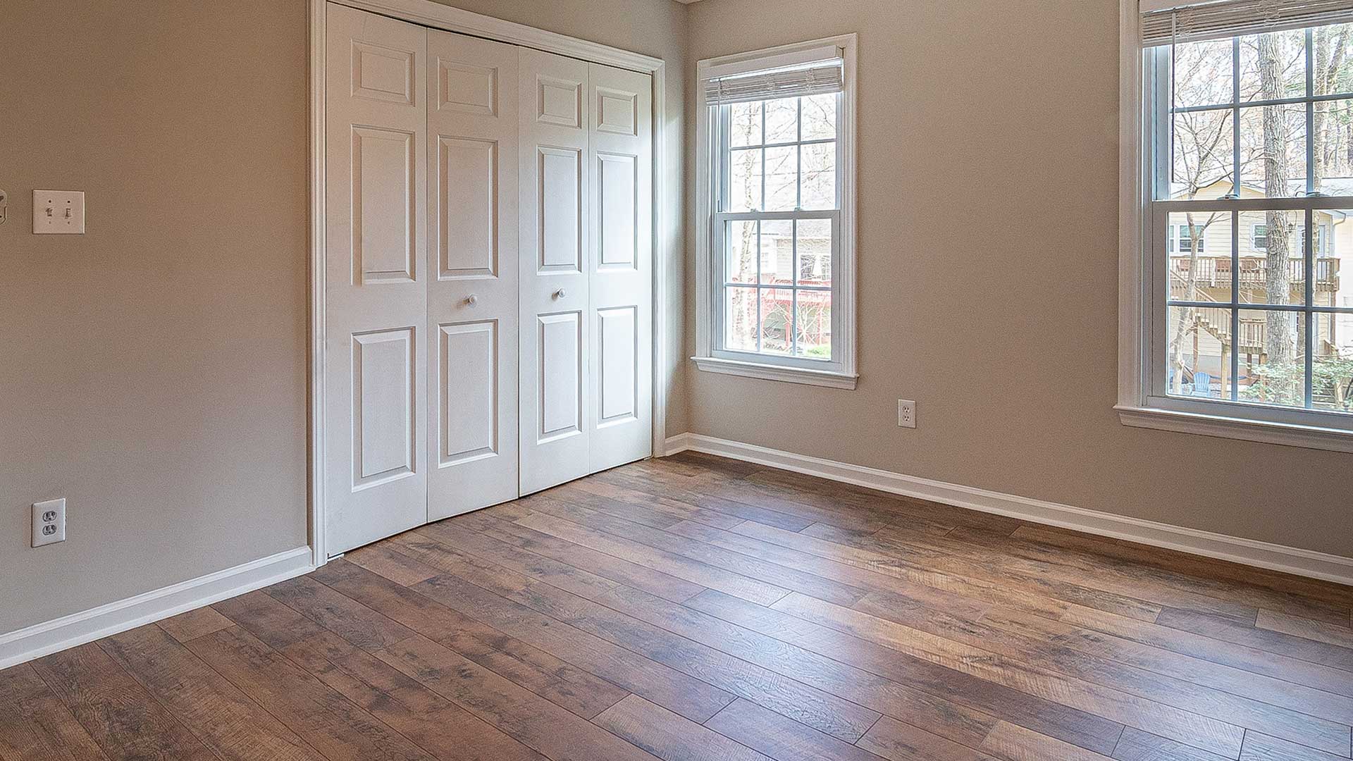 empty room featuring a closet with white bifold doors and wood flooring