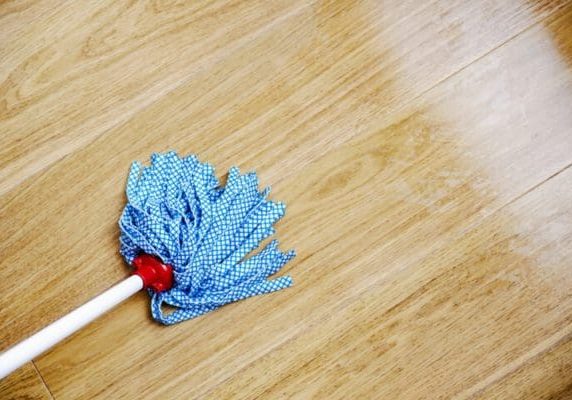 Mop on a clean hardwood floor representing proper hardwood floor care after refinishing or installation